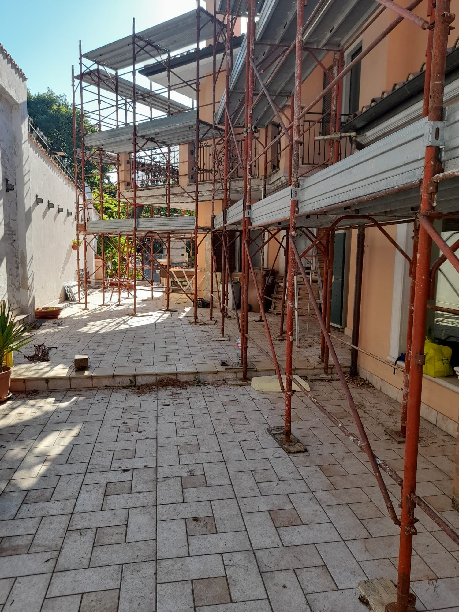 Cortile residenziale con ponteggi montati per lavori di manutenzione