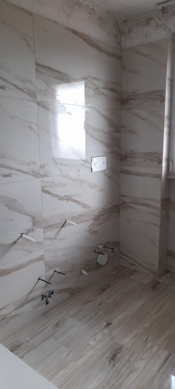 Bagno in ristrutturazione con rivestimento effetto marmo