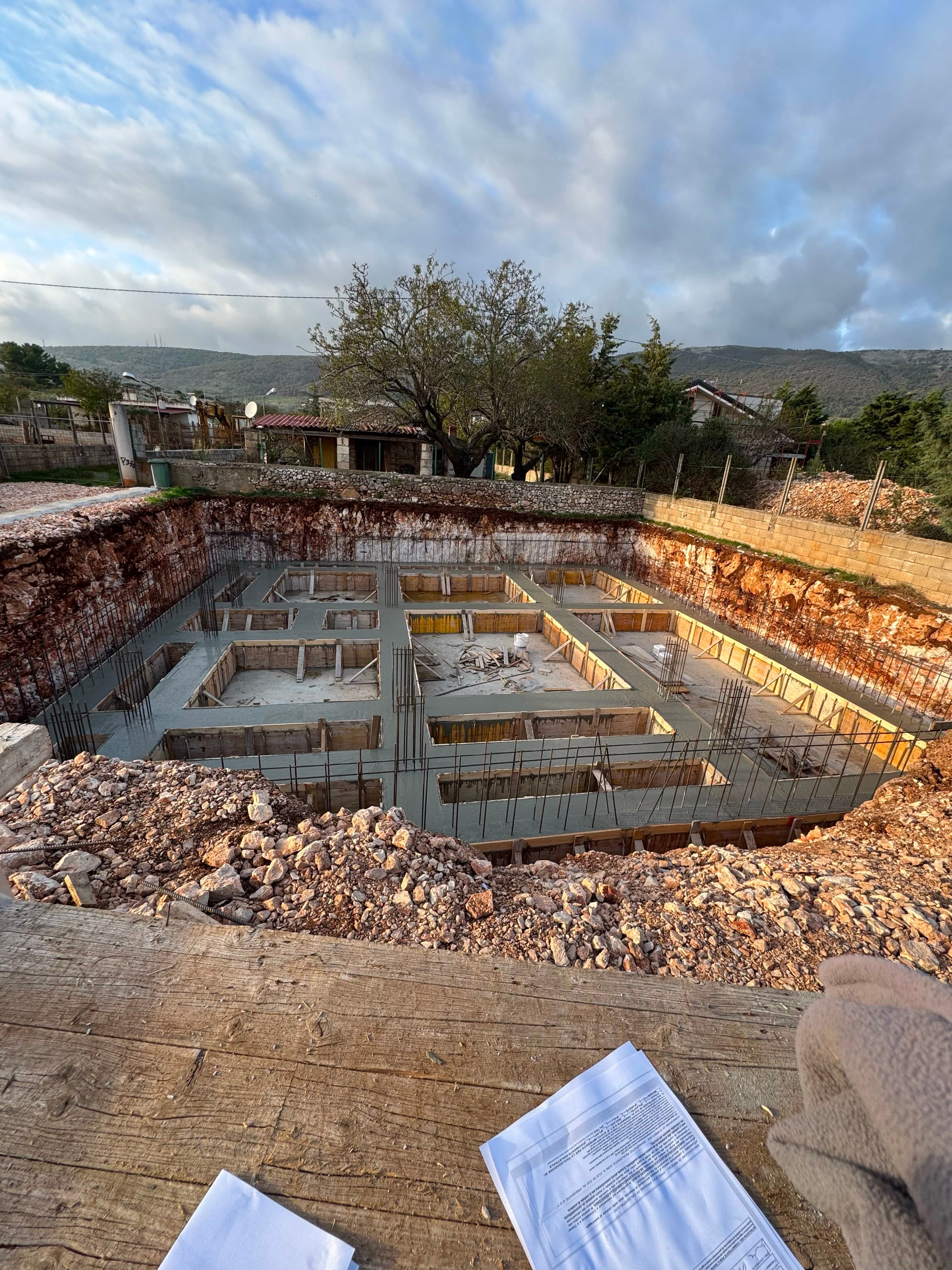 Cantiere esterno con struttura in legno e lavori edili in corso